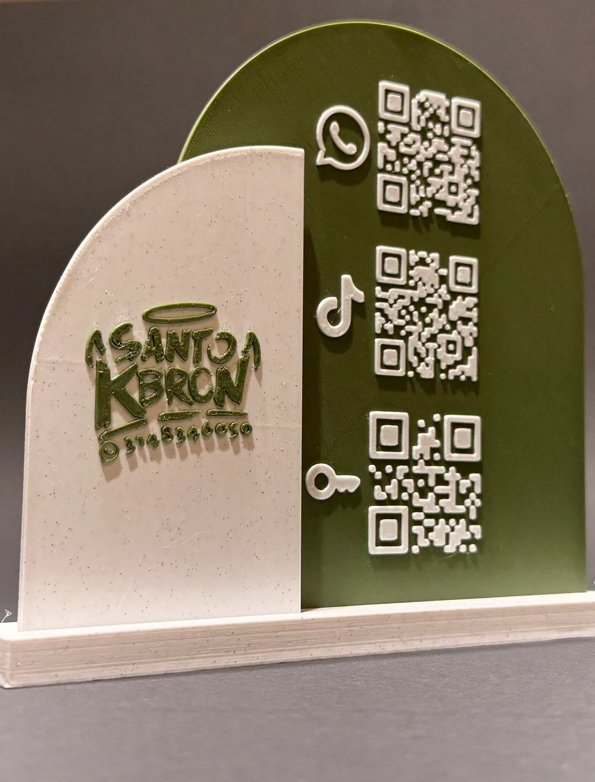 Detalle del logo del negocio en relieve sobre el panel blanco de la placa, con los tres códigos QR blancos del panel verde al lado derecho — Placa QR con base de Solid Lab 3D, Colombia