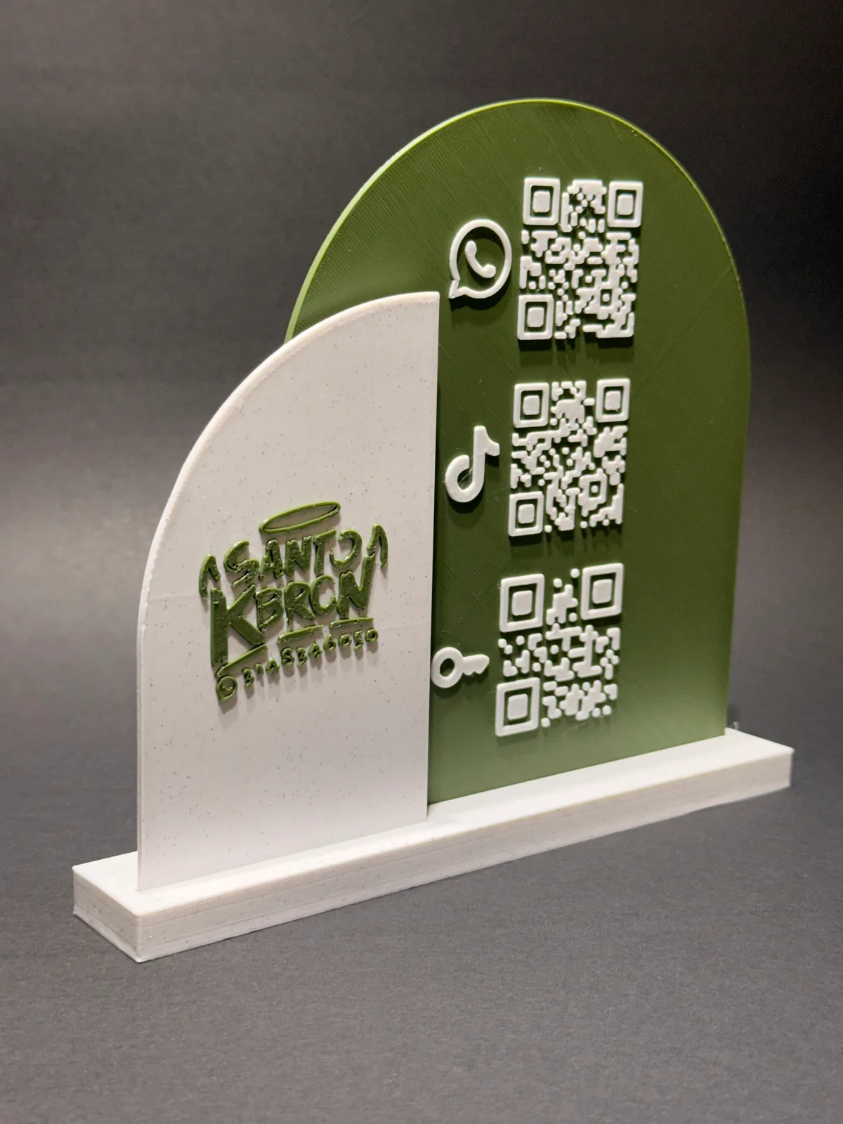 Placa QR con base verde y blanca girada casi de canto, con el panel blanco del logo por delante y el panel verde de los códigos por detrás — Solid Lab 3D, Colombia